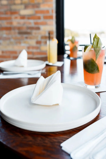 Reference image: Manufacturer lifestyle photo for Nature's Linen 40029 showing the napkin or guest towel in use. Supplied color: white. Decorative folds and display quantities are illustrative; this listing supplies the stated napkins or towels only. Food, beverages, glassware, plates, cutlery, furniture, plants and other props are not included. Dimensions, material, fold and case quantity are as listed above.